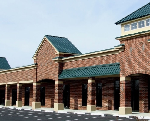 Red metal roofing installed on brick retail complex