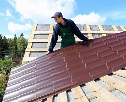 Technician installing white standing seam metal roof