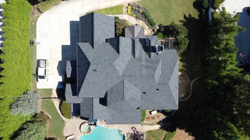 High-pitched gable roof with synthetic slate shingles on cream stucco home