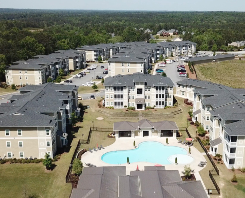 Aerial view of a large apartment complex in Atlanta, GA with well-maintained commercial roofing and a swimming pool