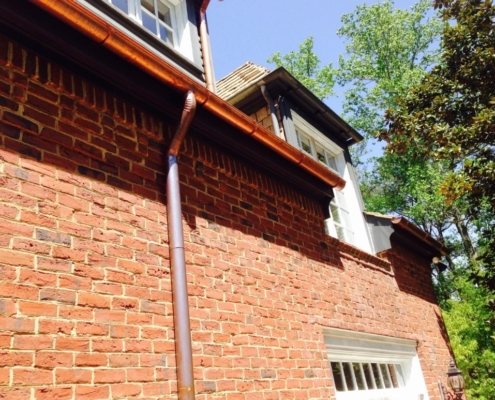 Copper gutter system installed on red brick home in Atlanta – Academy Roofing