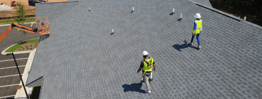Academy Roofing inspectors evaluating roof safety and insurance compliance