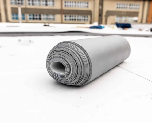 Roll of TPO roofing material on a flat commercial rooftop in Greater Atlanta
