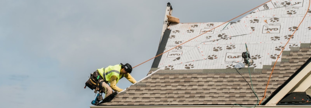 Academy Roofing crew member installing new shingles over fresh underlayment in Acworth, GA